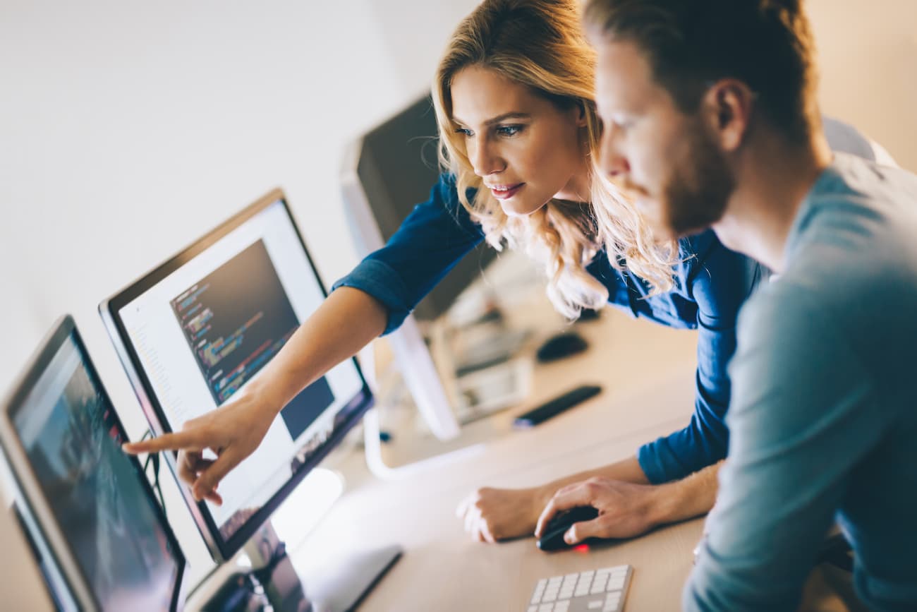 Frau und Mann analysieren Daten auf Computern, symbolisiert die Möglichkeit, Studienergebnisse in Echtzeit abzurufen und die klare Darstellung von Daten und Analysen.