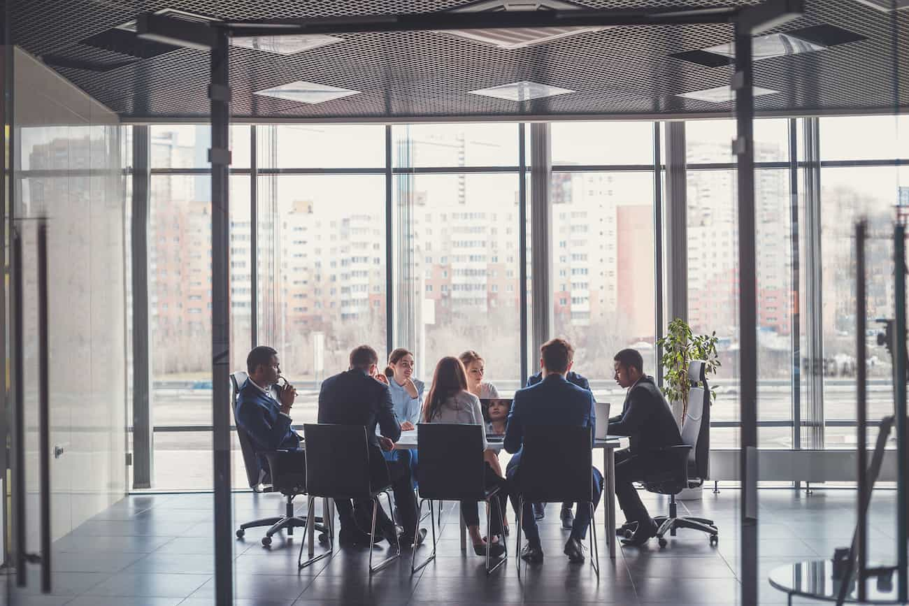 Team von Fachleuten in einem modernen Konferenzraum, symbolisiert die Mission, Unternehmen bei der Markteinführung zuverlässiger und fehlerfreier Software- und Hardwareprodukte zu unterstützen.