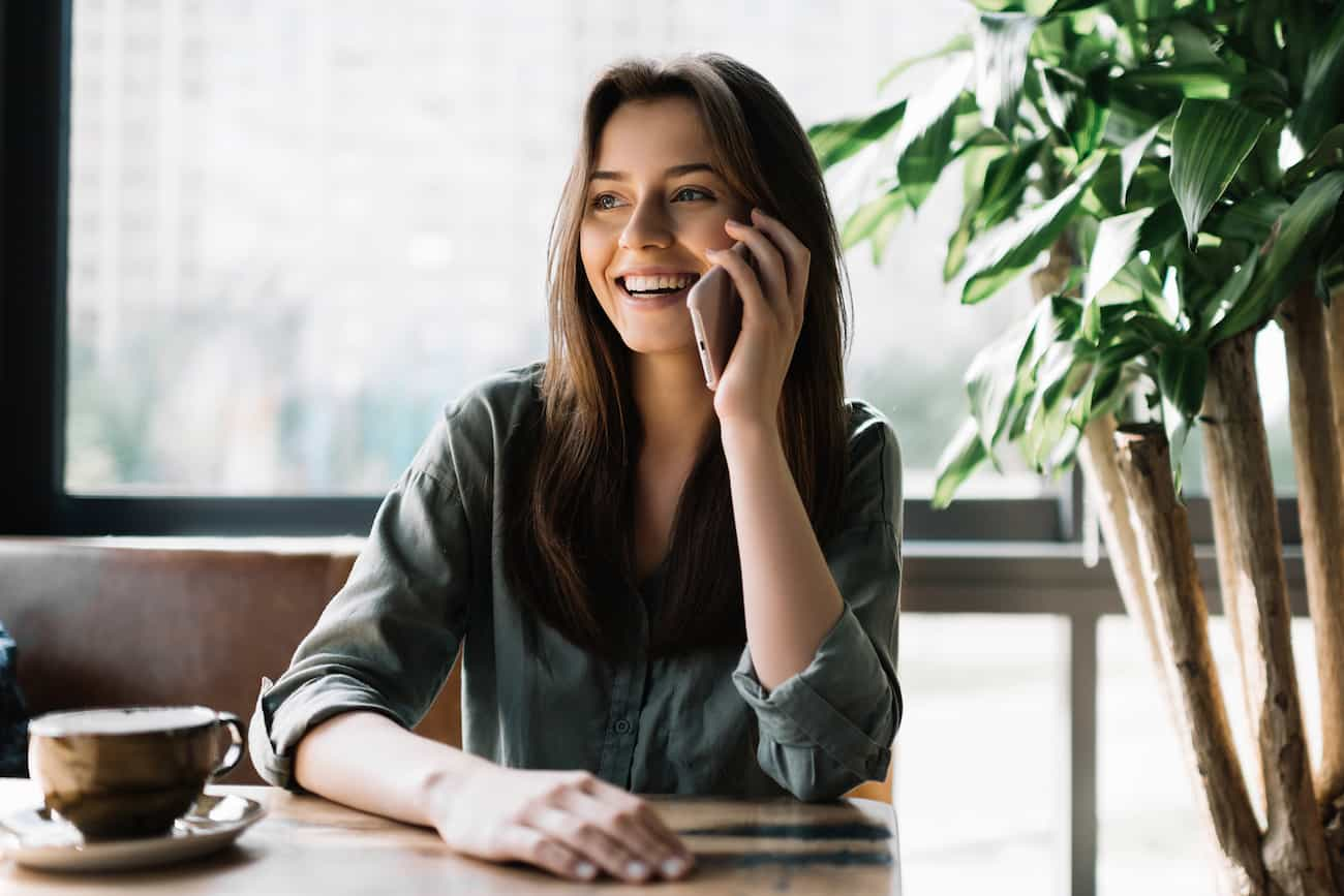 Frau am Telefon in einem Beratungsgespräch, um Projektanforderungen zu definieren und gemeinsam die nächsten Schritte für KI-Tests zu besprechen.